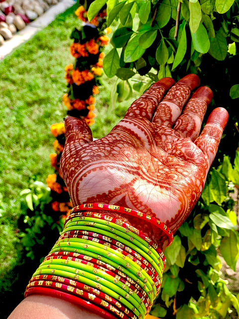 Women apply mehendi (henna) on their palms for Teej